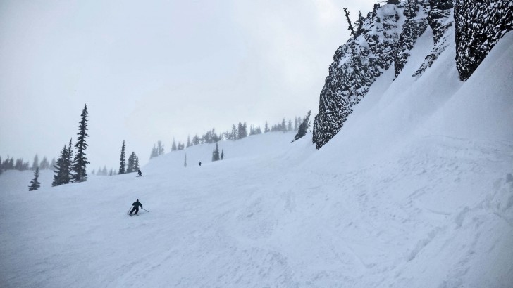 Skiers drop under the cliffs on Bomber Bowl, one of Mission Ridge's signature runs. Credit: John Nelson