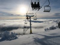 Skiers and snowboarders rise above the clouds on the Crystal Chair at Sun Peaks. Credit: John Nelson