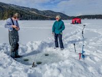 Ice fishing on Heffley Lake near Sun Peaks Resort with Elevated Fishing Adventures. Here, the guide and guest try their hand at outdoors holes. Credit: Yvette Cardozo