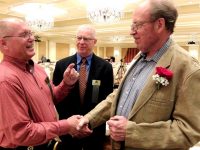 Honoree Howard Peterson (r) is warmly congratulated by Ski Archives Advisory Board members Tom Nielson (l) and Richard Hughes. Credit: Harriet Wallis